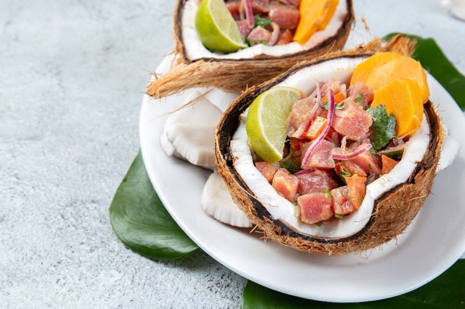Zwei halbe Kokosnussschalen, jeweils mit einem exotischen Salat, symbolisch für die Übertragung von Typhus über kontaminierte Lebensmittel oder Wasser.